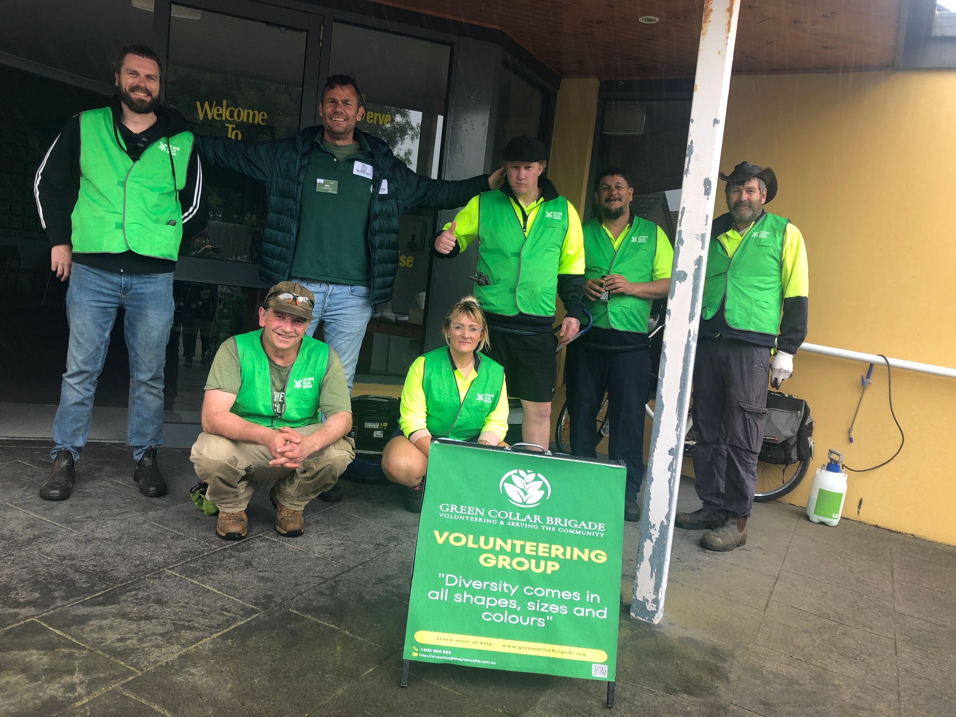 Brigade crew gathered outside a community centre with the volunteering banner